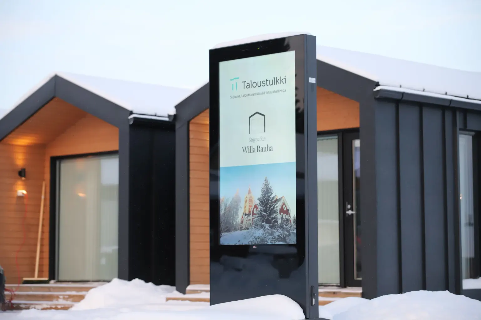 Ulkototeeminäyttö lumisessa pihassa – Taloustulkki