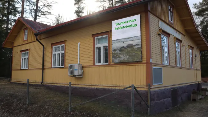 Seurakunnan ulkonäyttö keltaisessa puurakennuksessa